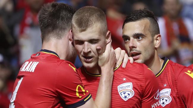 Adelaide United’s Riley McGree (centre) with Ryan Strain (left) and Nikola Mileusnic.