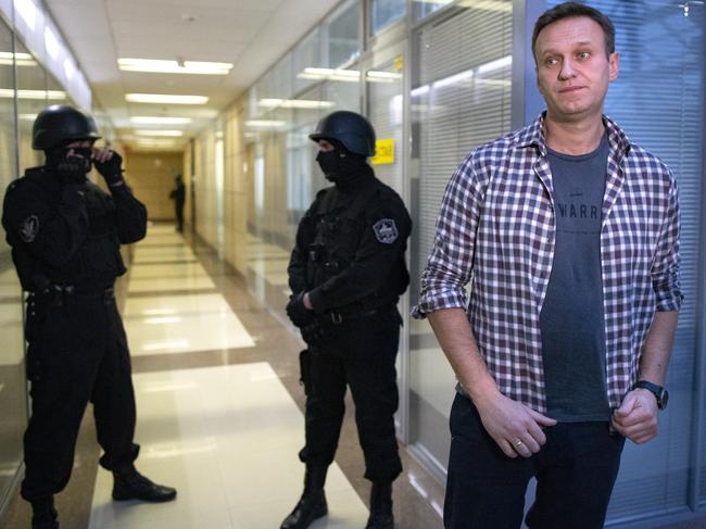 Russian opposition leader Alexei Navalny speaks to the media in front of security officers standing guard. Picture: AP