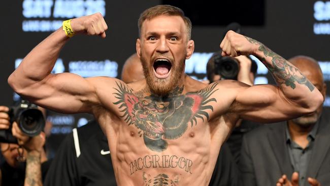 Conor McGregor poses on the scale during his official weigh-in.