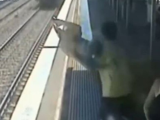 The father swings his child as if to throw them in front of the moving train. Live Leak