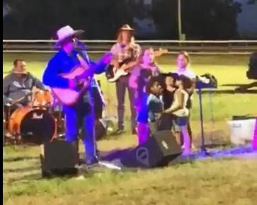 Children crowd around the microphone to sing for Dolly. Picture: Contributed