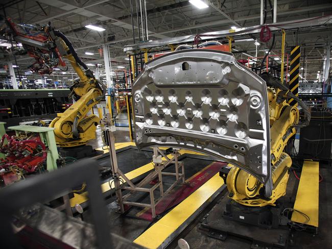 (FILES) In this file photo taken on August 26, 2016  a robot works with a part for a Fiat Chrysler Automobiles vehicle at the FCA Sterling Stamping Plant in Sterling Heights, Michigan. - The use of robots in US manufacturing has more than tripled over the two decades, and has doubled in the rest of the world, replacing certain categories of worker, according to a report published on July 15, 2019. As of 2017, automation in the United States had risen to 1.8 robots for every 1,000 workers from just 0.5 recorded 22 years earlier, according to research by the Federal Reserve Bank of St. Louis. The report found the highest prevalence of robots in the auto sector, with France in the lead, followed by the United States and Germany. (Photo by BILL PUGLIANO / GETTY IMAGES NORTH AMERICA / AFP)