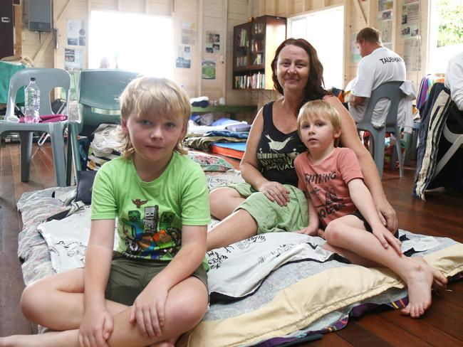 Tracy Walker and children, Tyler and Roman, at Machans Beach Community Hall, seek refuge after their home was inundated by floodwaters. Picture: Peter Carruthers