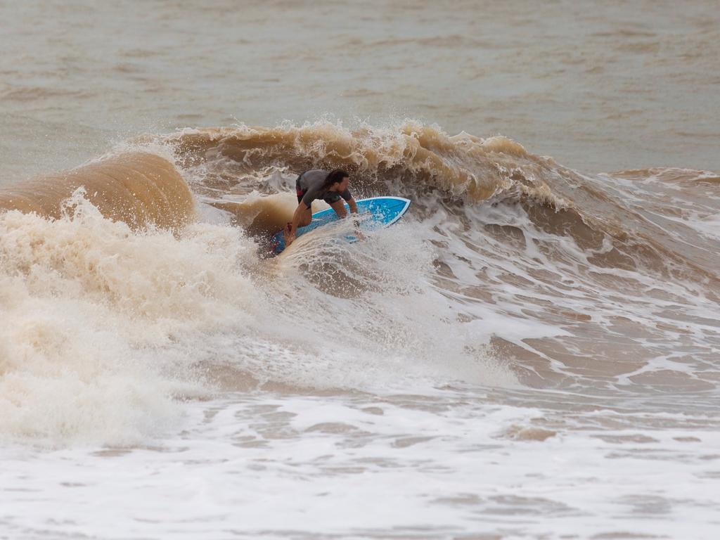 A surfer takes on the cyclone Anika swell on the Nightcliff Beach on Saturday afternoon. Picture: Floss Adams.