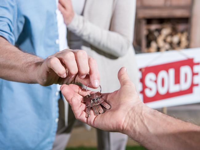 close up view of saleman giving keys of house to new owners