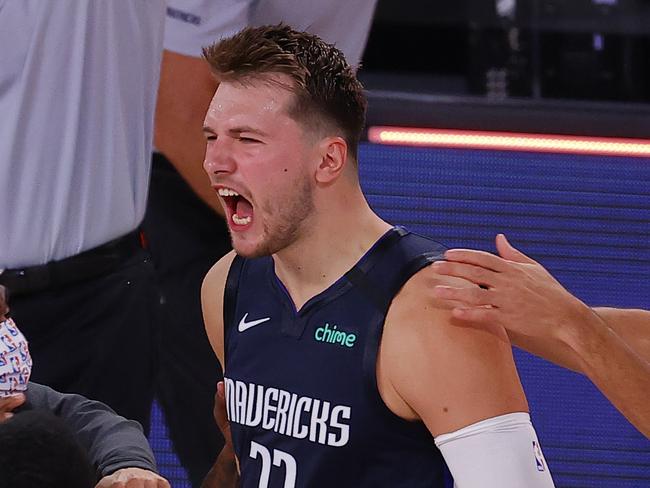 LAKE BUENA VISTA, FLORIDA - AUGUST 23: Luka Doncic #77 of the Dallas Mavericks celebrates a game winning three point basket with teammates against the LA Clippers during overtime in Game Four of the Western Conference First Round during the 2020 NBA Playoffs at AdventHealth Arena at ESPN Wide World Of Sports Complex on August 23, 2020 in Lake Buena Vista, Florida. NOTE TO USER: User expressly acknowledges and agrees that, by downloading and or using this photograph, User is consenting to the terms and conditions of the Getty Images License Agreement.  (Photo by Kevin C. Cox/Getty Images)