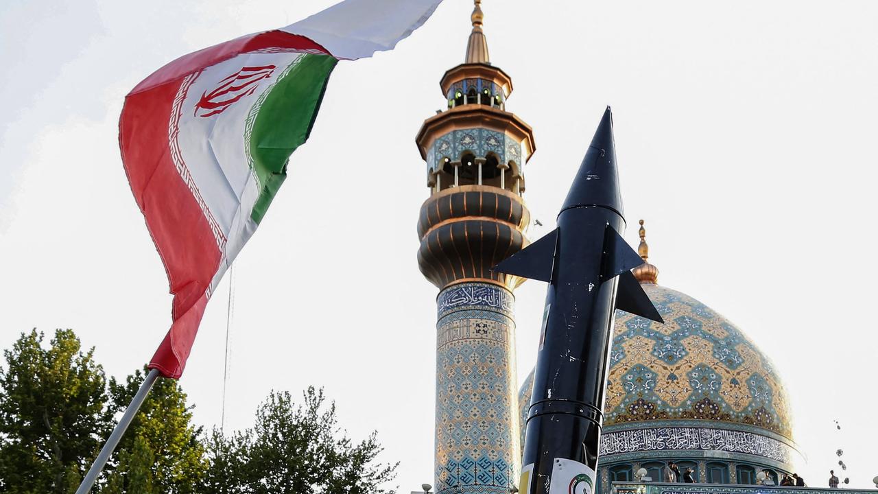 Iranians lift up a flag and the mock up of a missile during a celebration following Iran's missiles and drones attack on Israel. Picture: AFP.