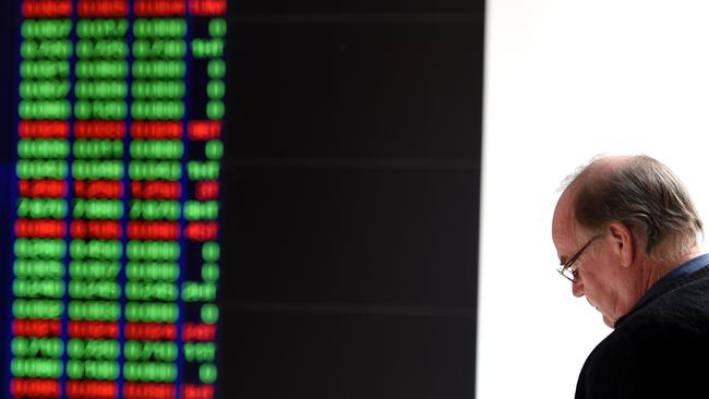 Hard economic times ... a man watches the ASX trading board in Sydney. Picture: AAP