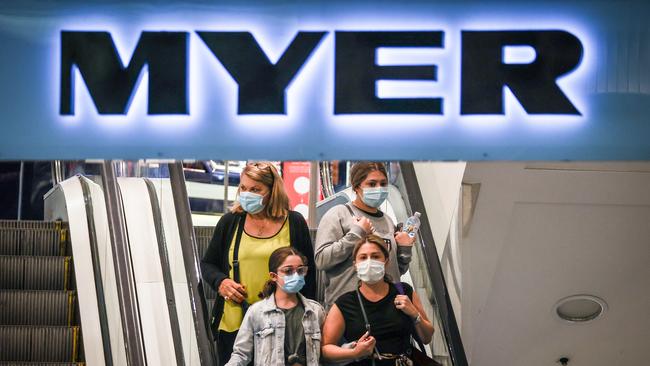 Shoppers wearing face masks ride an escalator as they exit the Myer store in Pitt St on Saturday morning. Picture: Getty