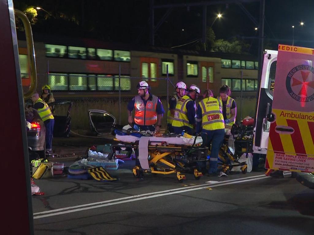 Pictured are emergency services attending a car crash after a Police pursuit on Railway Parade, Canley Vale when the vehicle being pursued lost control and hit a telegraph pole trapping two people. Picture: TNV