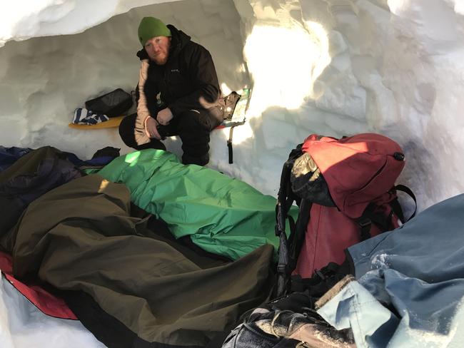 Senior Constable Dave Tickell in a snow cave built during a training exercise in the Snowy Mountains. Picture: Supplied