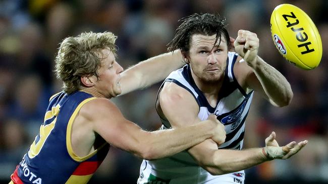 Patrick Dangerfield gets a handball away under pressure from Rory Sloane at Adelaide Oval. photo Calum Robertson