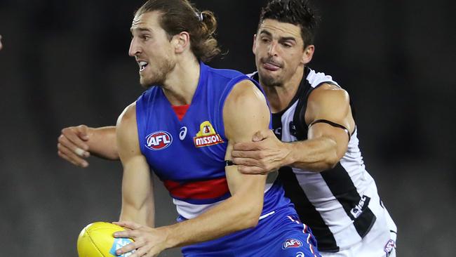 AFL Round 1. Western Bulldogs v Collingwood at Marvel Stadium..  21/03/2020.  Marcus Bontempelli of the Bulldogs looks to clear as Scott Pendlebury of the Magpies tackles   . Pic: Michael Klein