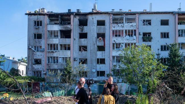 Journalists work near a block of flats hit by a missile fragment in Lviv, which has been one of Ukraine’s safer big cities, Picture: Getty Images