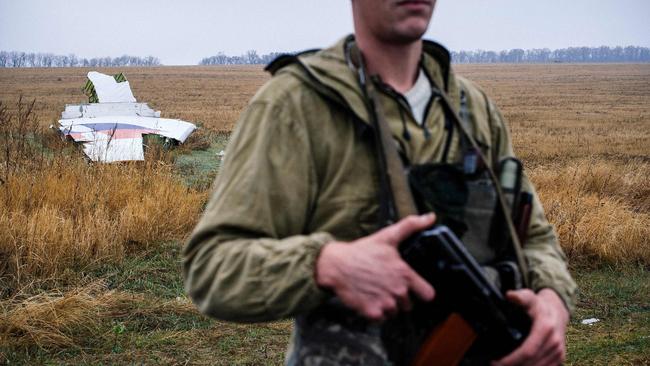 (FILES) In this file photo taken on November 10, 2014 a pro-Russian gunman stands guard next to parts of the Malaysia Airlines Flight MH17 at the crash site near the village of Hrabove (Grabovo), some 80 kms east of Donetsk. - A court in Ukraine on September 5, 2019 released from pre-trial detention a man suspected of involvement in the downing of flight MH17, amid speculation he may be used in a prisoner swap with Russia. Ukraine captured Vladimir Tsemakh, accused of fighting for pro-Russian separatists, in June, but he is believed to be a person of interest in the downing of MH17. European lawmakers described him as a "key suspect" and asked Kiev to make him available for testimony in the probe. (Photo by Dimitar DILKOFF / AFP)