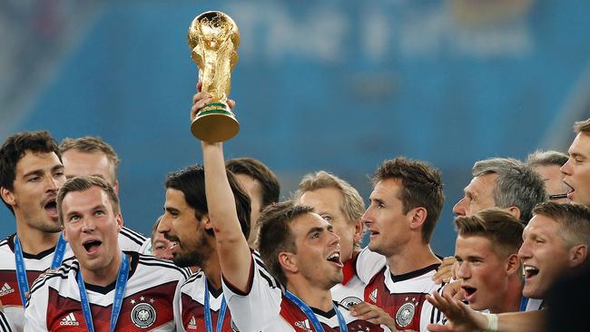 Germany's defender and captain Philipp Lahm (C) holds The World Cup.