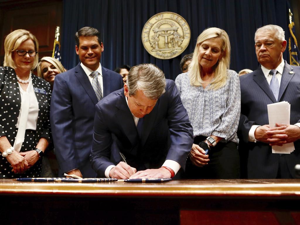 Georgia’s Republican Governor Brian Kemp, centre, signs legislation. Picture: AP