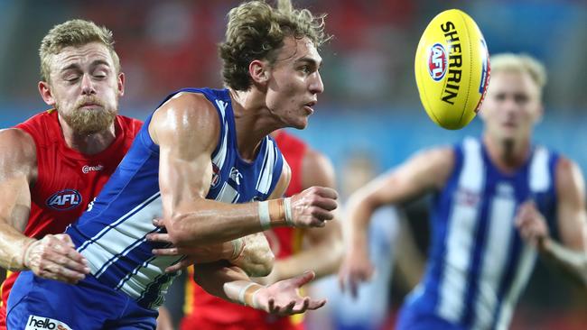 GOLD COAST, AUSTRALIA - MARCH 27: Charlie Lazzaro of the Kangaroos handballs during the round 2 AFL match between the Gold Coast Suns and the North Melbourne Kangaroos at Metricon Stadium on March 27, 2021 in Gold Coast, Australia. (Photo by Chris Hyde/Getty Images)