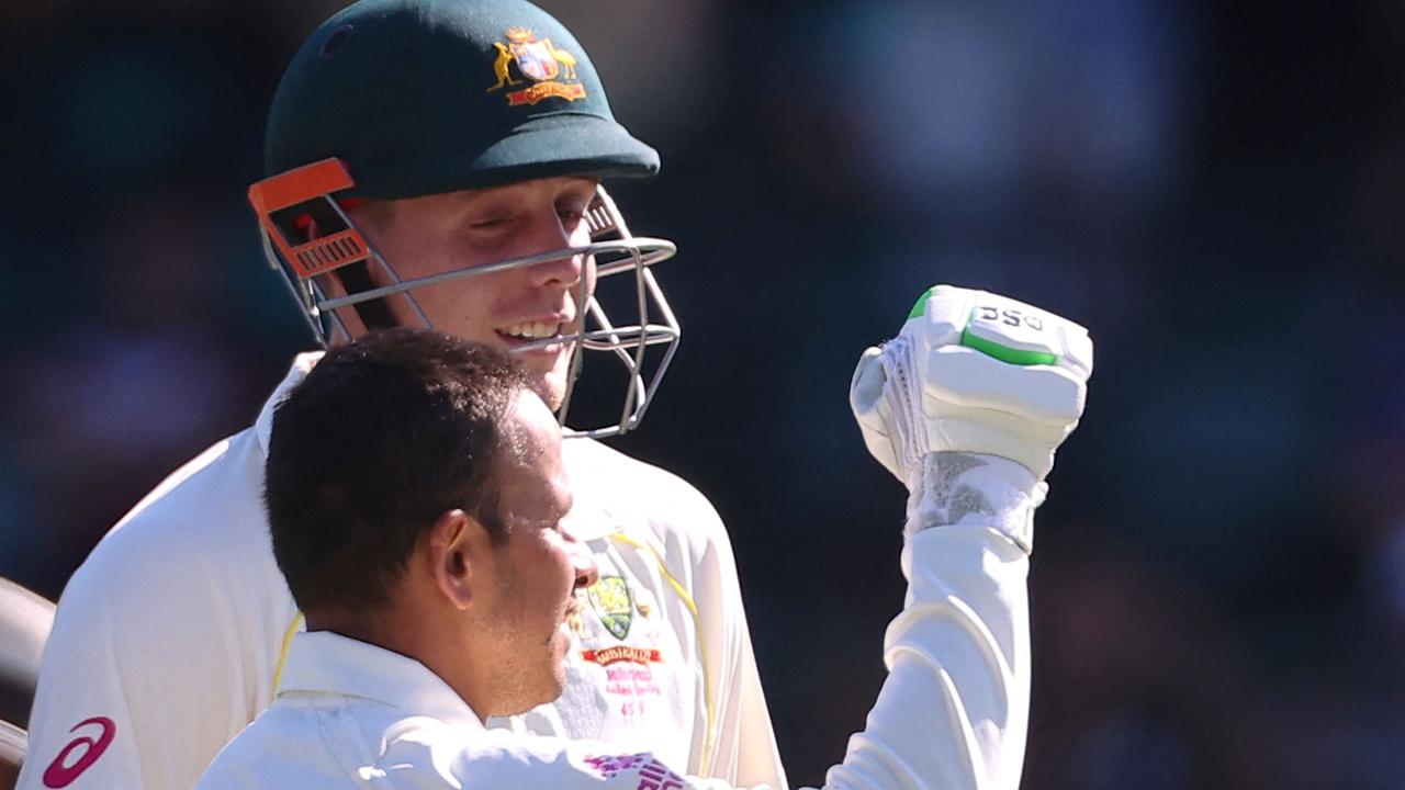 Australia's Usman Khawaja (R) celebrates with teammate Cameron Green after reaching his century (100 runs) on day four of the fourth Ashes cricket test between Australia and England at the Sydney Cricket Ground (SCG) on January 8, 2022. (Photo by DAVID GRAY / AFP) / -- IMAGE RESTRICTED TO EDITORIAL USE - STRICTLY NO COMMERCIAL USE --