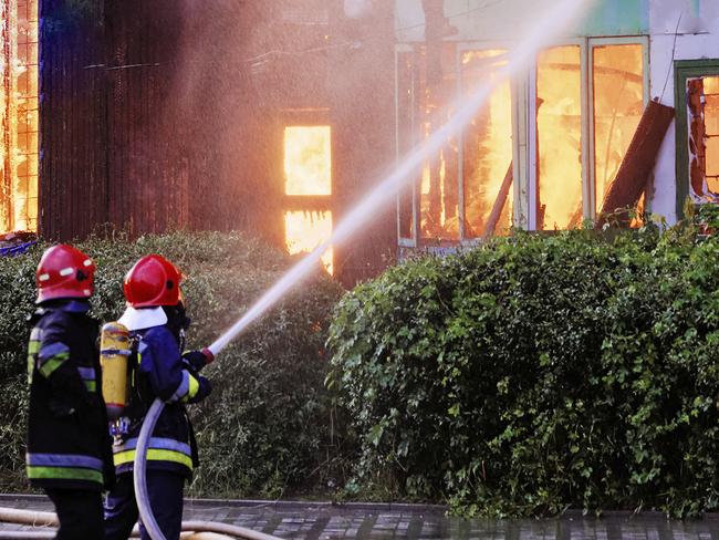 Firemen in action on burning ruins of buildingFire Open day