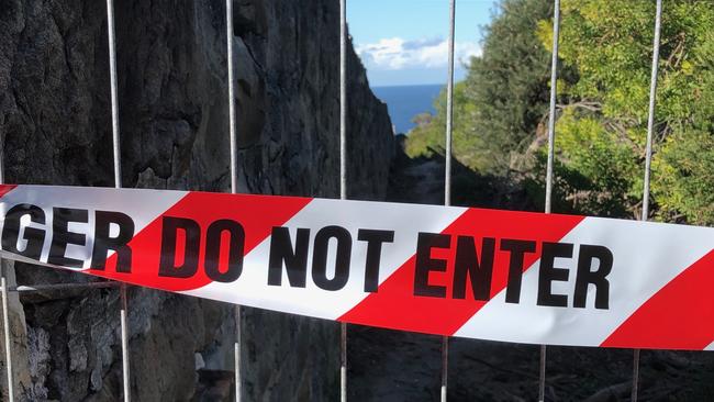 Keep out signs and barriers along a historic wall on the boundary of Sydney Harbour National Park and North Fort, on North Head. Picture: Jim O'Rourke,