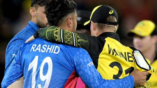 Australia's David Warner (R) embraces Afghanistan's Rashid Khan after the ICC men's Twenty20 World Cup 2022 cricket match between Australia and Afghanistan at Adelaide Oval on November 4, 2022 in Adelaide. (Photo by Brenton EDWARDS / AFP) / -- IMAGE RESTRICTED TO EDITORIAL USE - STRICTLY NO COMMERCIAL USE --