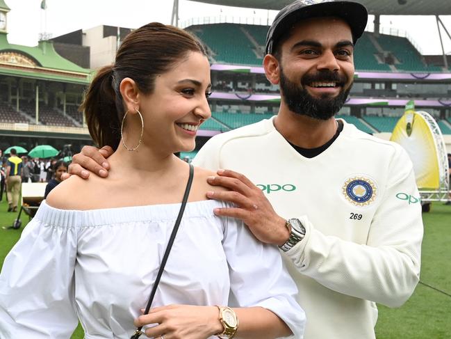 (FILES) In this file photo taken on January 7, 2019, India's captain Virat Kolhi and his wife Anushka Sharma walk on the field as they celebrate India's series win on the fifth day of the fourth and final cricket Test against Australia at the Sydney Cricket Ground in Sydney. - Indian cricketing star Kohli on August 27 announced that he and his Bollywood actress wife Anushka are expecting their first child in January next year. (Photo by Peter PARKS / AFP) / -- IMAGE RESTRICTED TO EDITORIAL USE - STRICTLY NO COMMERCIAL USE --