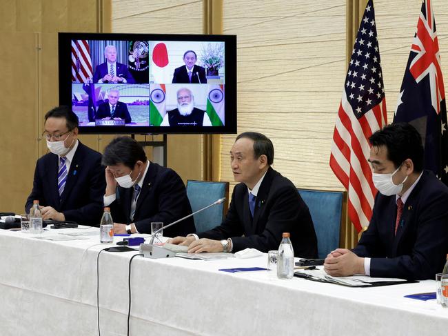 Japan's Yoshihide Suga (2R) speaks next to a monitor displaying the virtual meeting of US President Joe Biden (top L), Scott Morrison (bottom L) and Narendra Modi during the virtual Quad meeting. Picture: AFP