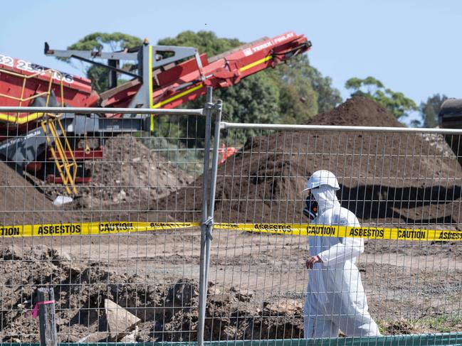 06-03-2024 Workers in protective equipment move contaminated soil with asbestos signs around the building site in Murray Road, Queenscliff. Picture: Brad Fleet