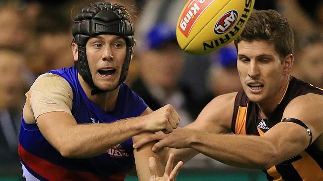 Caleb Daniel handballs under pressure from Luke Breust. Picture: Wayne Ludbey