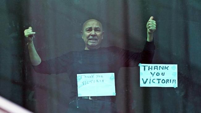 A man gestures from his hotel room as he prepares to leave the Crown Promenade Hotel after spending two weeks in forced quarantine in Melbourne. Picture: Scott Barbour/AAP