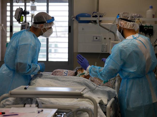 Israeli medical personnel tend to Covid-19 patients inside a coronavirus isolation ward at the Ziv Medical Centre in the city of Safed in northern Israel on August 12, 2021. - Over the past week, Israel has been recording an average of more than 3,000 new coronavirus cases a day, the highest since April. (Photo by JALAA MAREY / AFP)