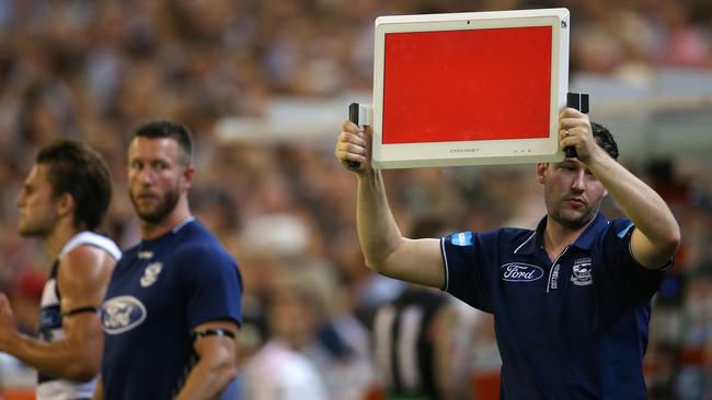 Geelong officials work the bench with a board on red. Picture: Michael Klein.