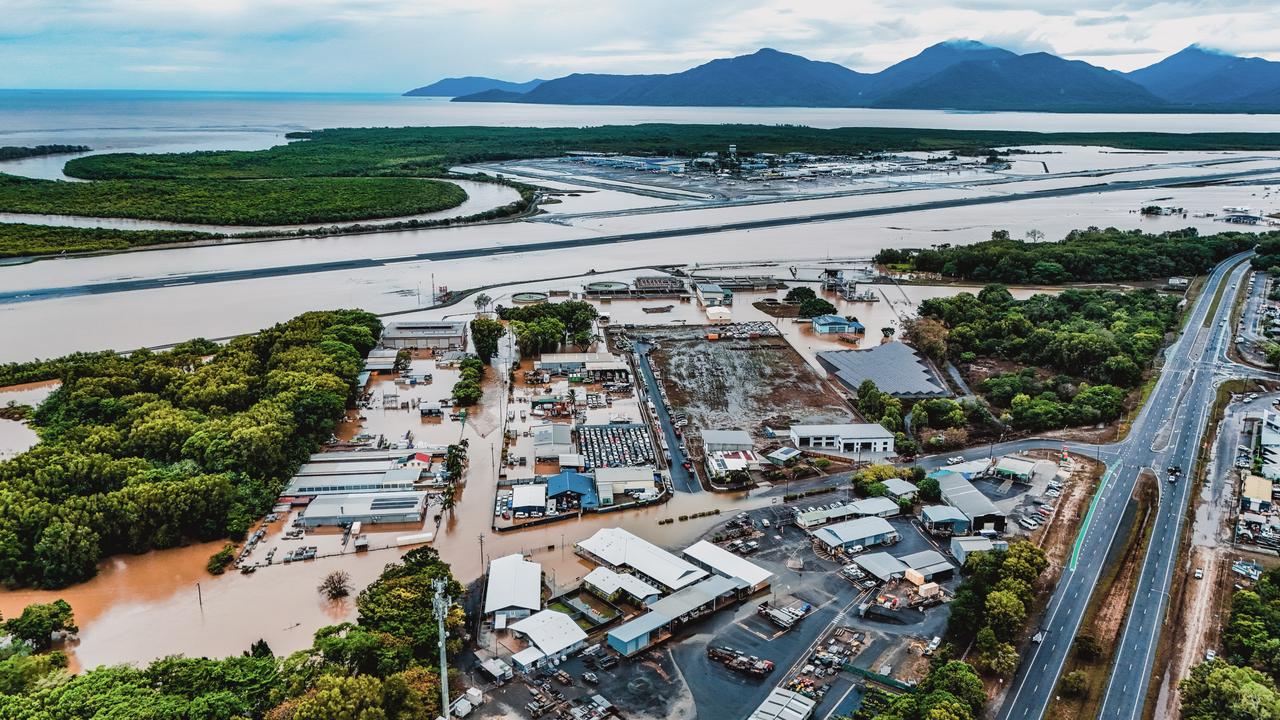 An aerial view shows a submerged runway at Cairns Airport, as travel in the region grinds to a halt. Picture: Liv Cole