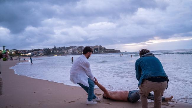 A group of mates save their friend from a wave. Picture: NCA NewsWire / Mario Francisco 