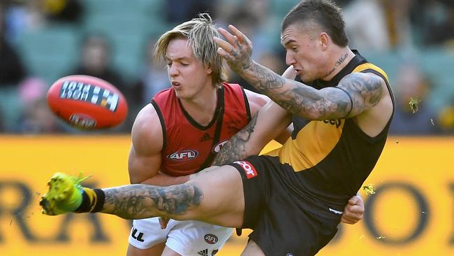 Dustin Martin gets a kick away under pressure from Darcy Parish.