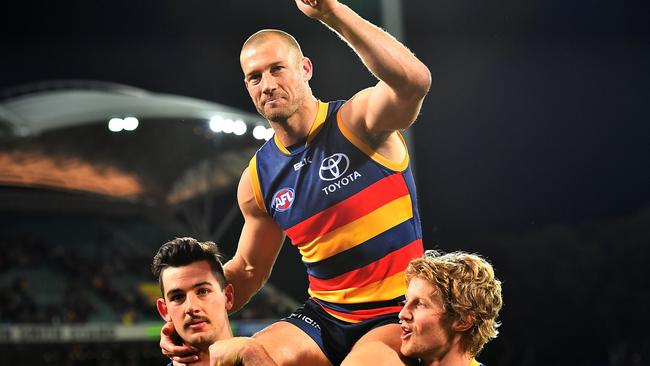 Scott Thompson is chaired off the field after playing his 300th game by Taylor Walker and Rory Sloane. (Photo by Daniel Kalisz/Getty Images)