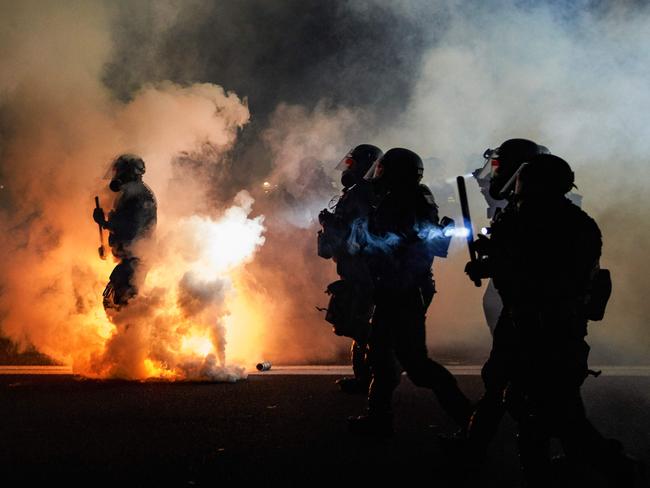 TOPSHOT - Oregon Police wearing anti-riot gear march towards protesters through tear gas smoke during the 100th day and night of protests against racism and police brutality in Portland, Oregon, on September 5, 2020. - Police arrested dozens of people and used tear gas against hundreds of demonstrators in Portland late on September 5 as the western US city marked 100 days since Black Lives Matter protests erupted against racism and police brutality. Protests in major US cities erupted after the death of African American George Floyd in May 2020 at the hands of a white police officer in Minneapolis. (Photo by Allison Dinner / AFP)