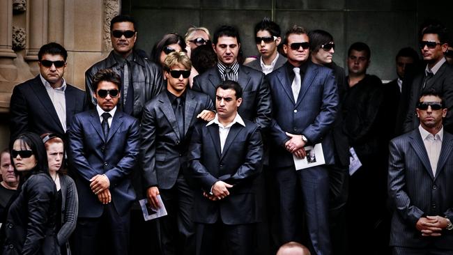 John Ibrahim stands with his two bodyguards during a funeral service. Picture: Greenhill Craig