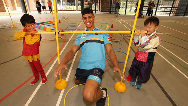 Members of the Titans coming to meet kids and parents at St Joseph's College Pimpama. Titans youth member Alofiana Khan Pereira has the bar set by five year old students Shriyansh Bodhanapally and Siwoo Kim. Picture Glenn Hampson