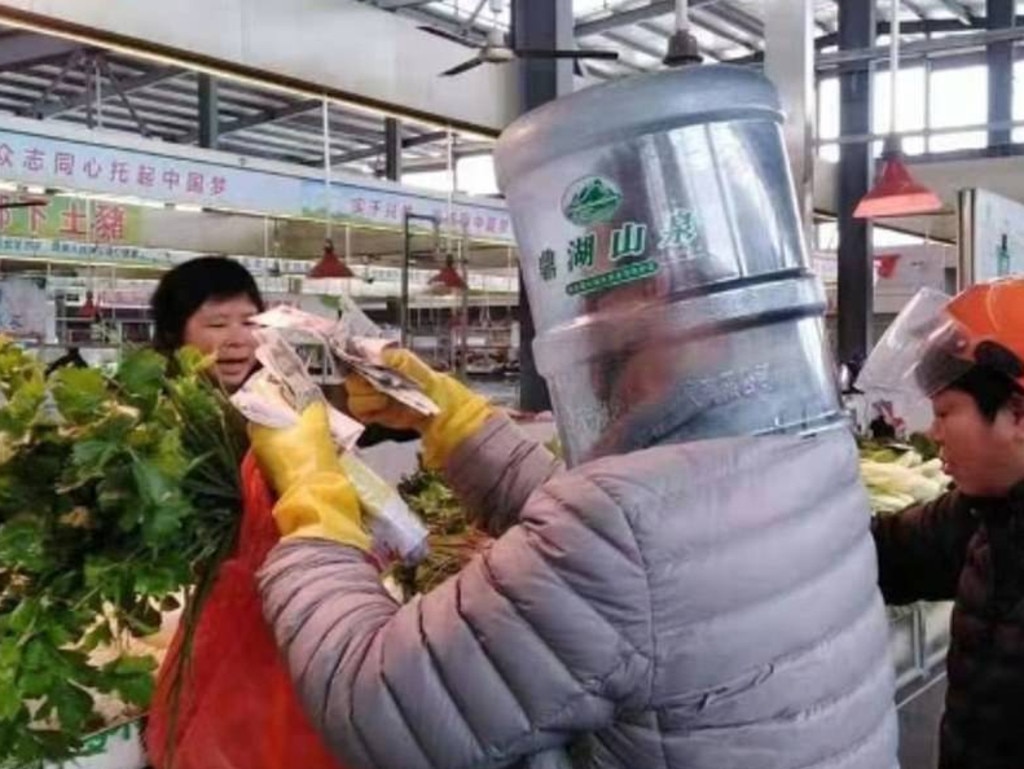 Shopping at the fruit market with a water cooler bottle and a scooter helmet. Picture: Weibo