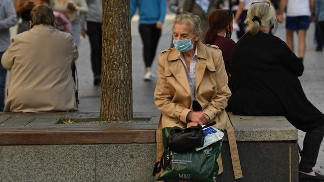 A woman wearing a protective face mask sits in Liverpool city centre, northwest England. The UK has one of the worst obesity rate - two out of three adults are overweight or obese. Picture: AFP