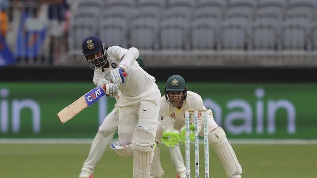 India's Ajinkya Rahane bats in front of Australia's Tim Paine during play.