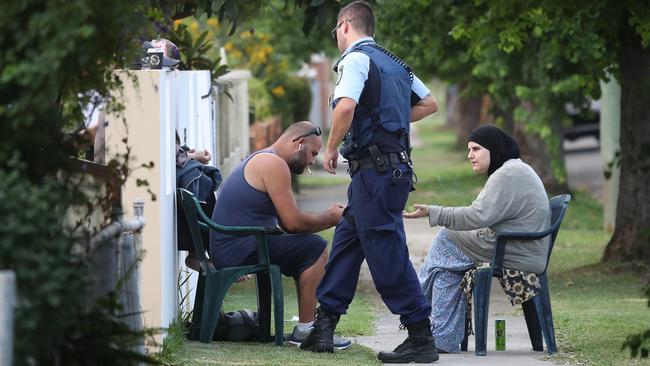 A man and woman talk to police outside a home in Francis St, Fairfield.