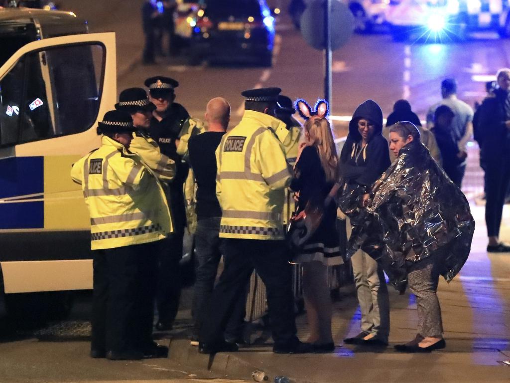 Emergency services personnel speak to people outside Manchester Arena after reports of an explosion at the venue during an Ariana Grande concert in Manchester. Picture: AP