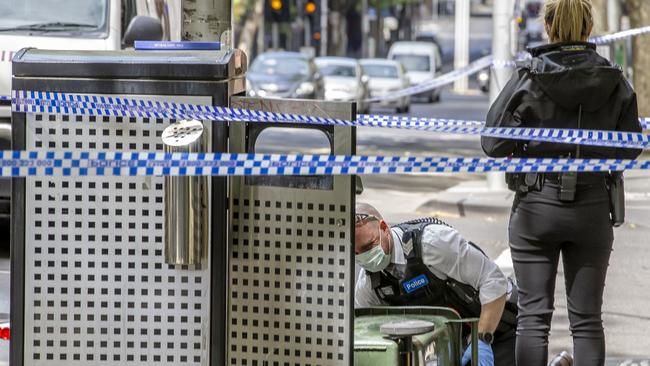 Officers scour a bin in the search for evidence. Picture: Tim Carrafa