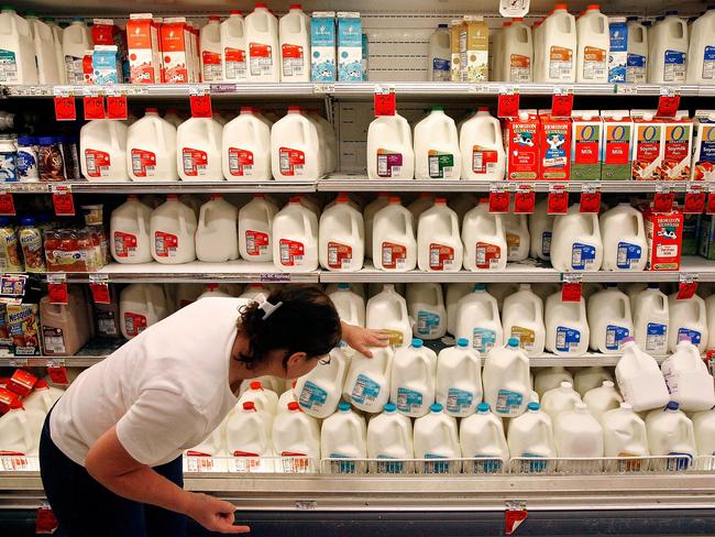 WIRE: Customer looking at the expiration date on cartons of milk in Safeway grocery supermarket store in Washington DC, USA 20 Aug 2007.