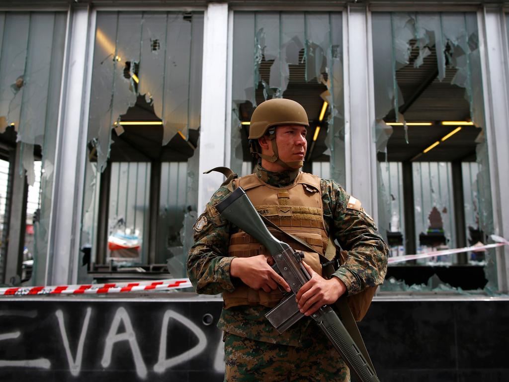 A Chilean army soldier stands guard outside the Plaza Maipu Metro station after a day of violent protests over an increase in the price of train tickets. Picture: AFP