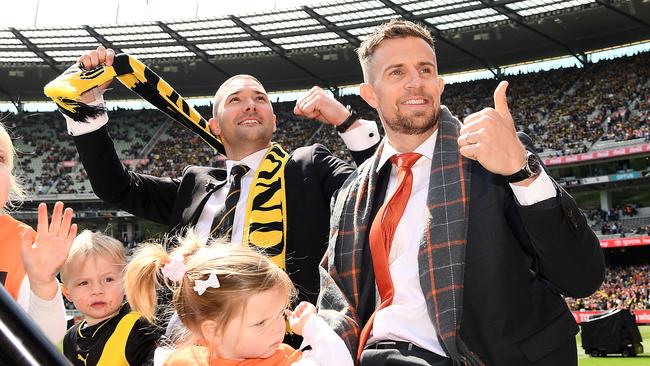 Shaun Grigg and Brett Deledio wave to the crowd during the 2019 AFL Grand Final match between Richmond and GWS. Picture: Quinn Rooney/Getty Images