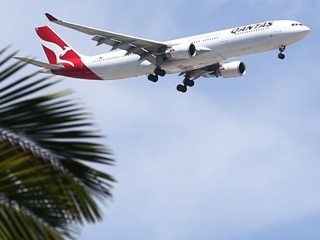 A Qantas passenger jet airplane comes into land at Cairns Airport over sunny skies and palm trees. Domestic tourism will be strong in Far North Queensland over the Easter school holidays, with advance hotel bookings already high. Picture: Brendan Radke